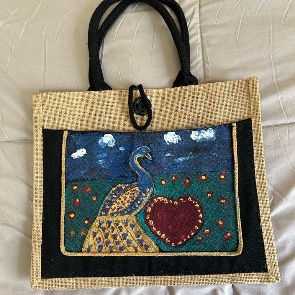 Hand-painted jute tote bag featuring a peacock and heart design.